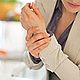 Weibliche Person hat Schmerzen am Handgelenk | Tiger Balm